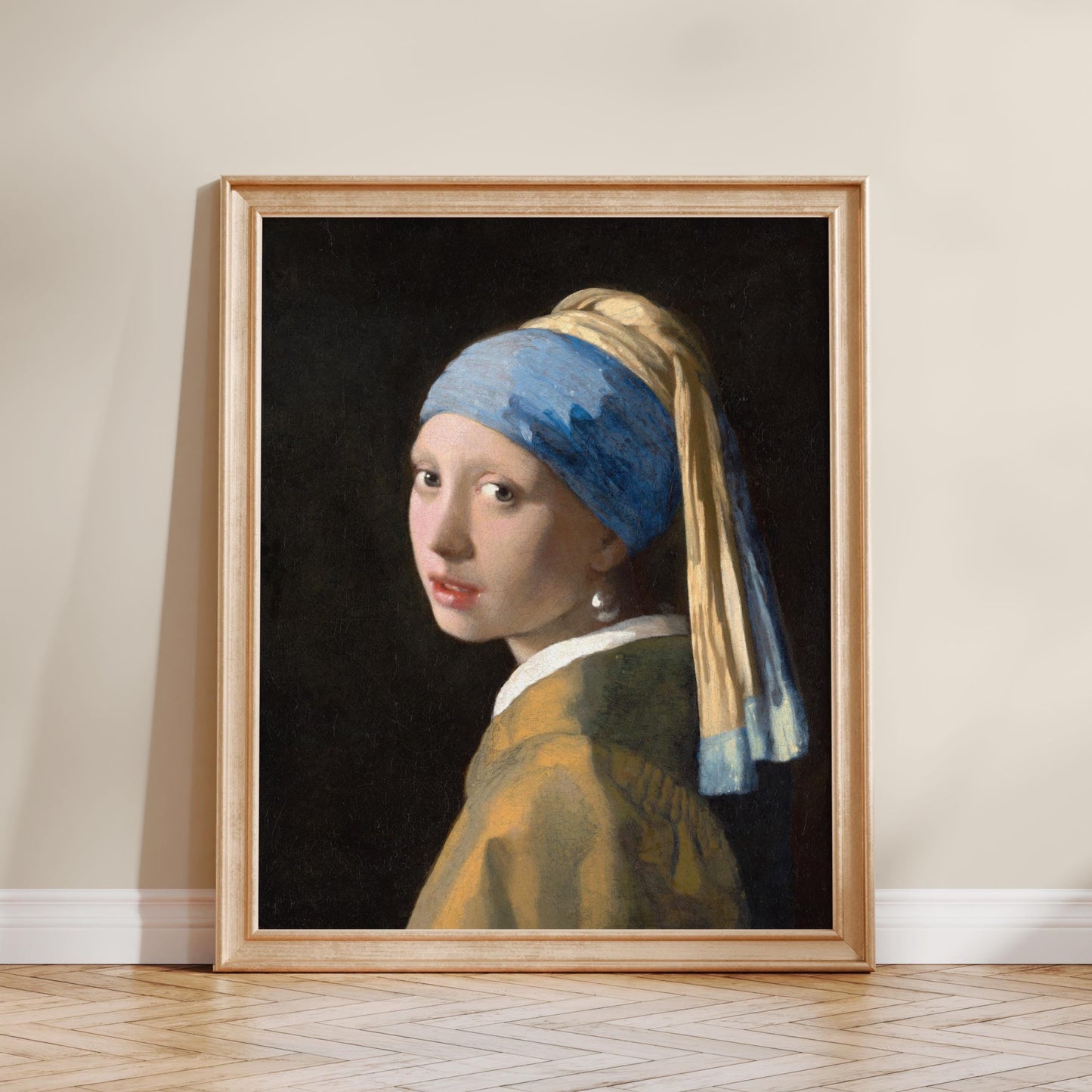 The image is a framed painting of a young woman with a pearl earring, wearing a yellow dress and a blue headscarf.
