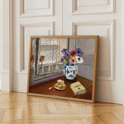 A framed painting depicting a vase of flowers on a table, with a book and a cup of coffee nearby, set against a window with a white curtain.