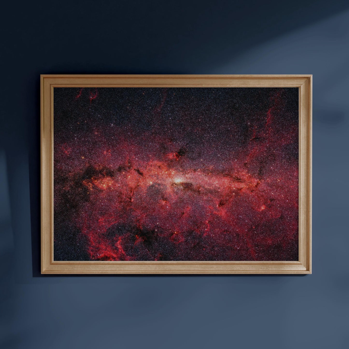The image is a framed photograph of a distant galaxy, with a vibrant red and orange color palette and a dark background.