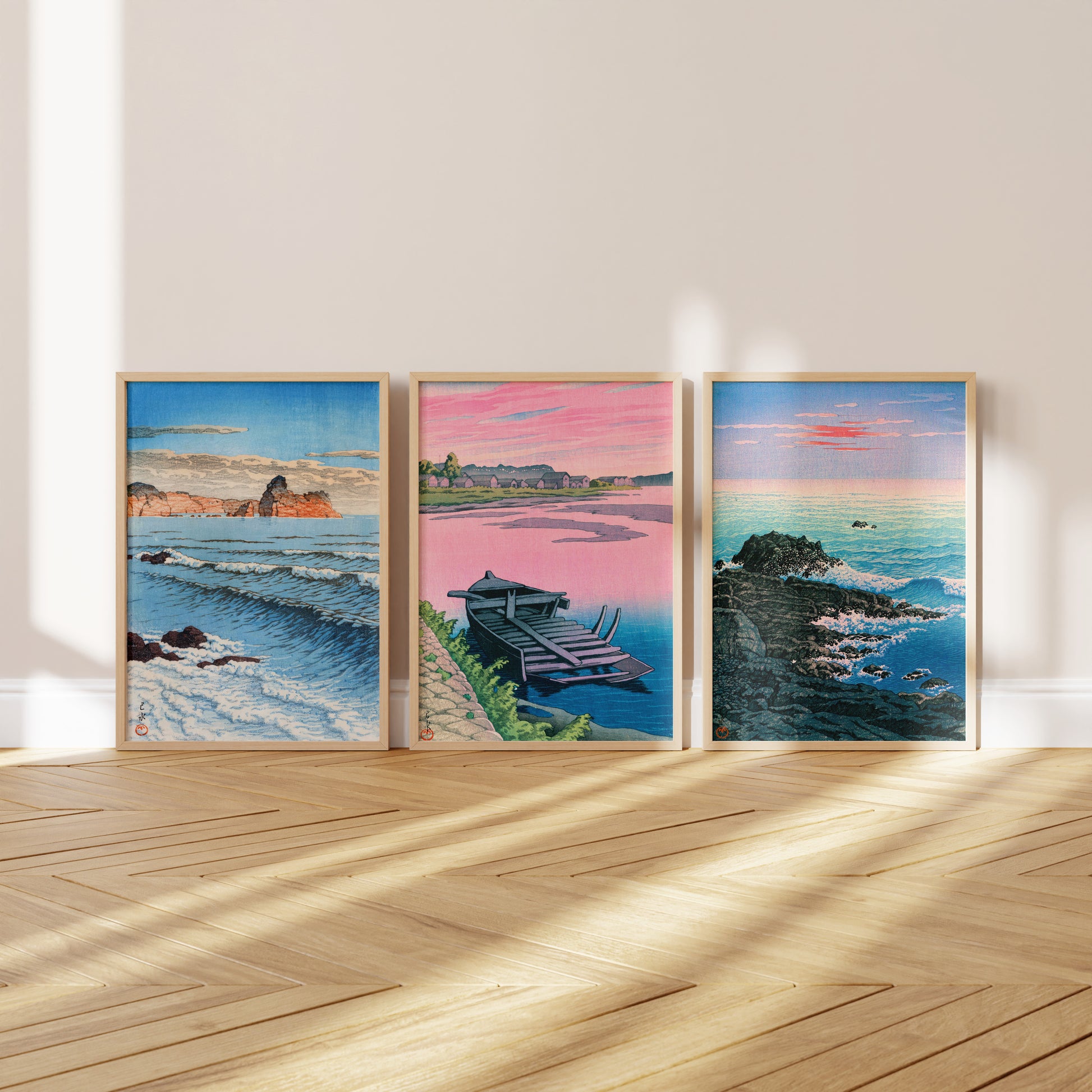 three framed artworks depicting different landscapes, including a seascape, a mountain range, and a coastal scene.