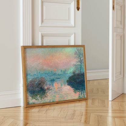 a painting of a serene landscape with a body of water and a sunset in the background, displayed on a wooden floor in a room with white walls.
